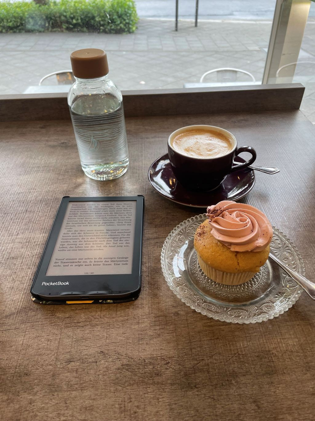 Kleine 400ml Trinkflasche aus Glas beim Lesen im Café – nachhaltiger Begleiter für unterwegs