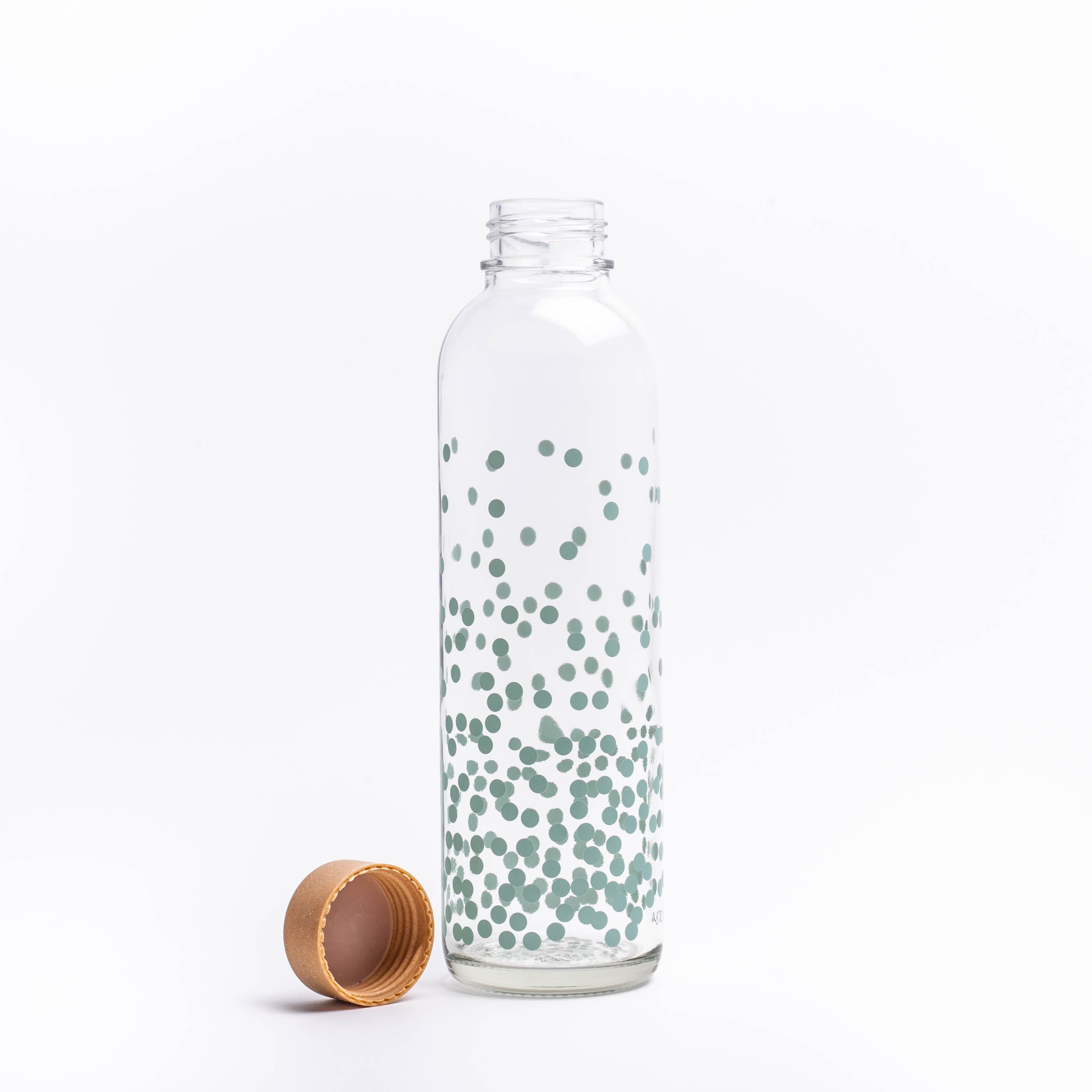 Glastrinkflasche mit blauen Punkten neben Deckel