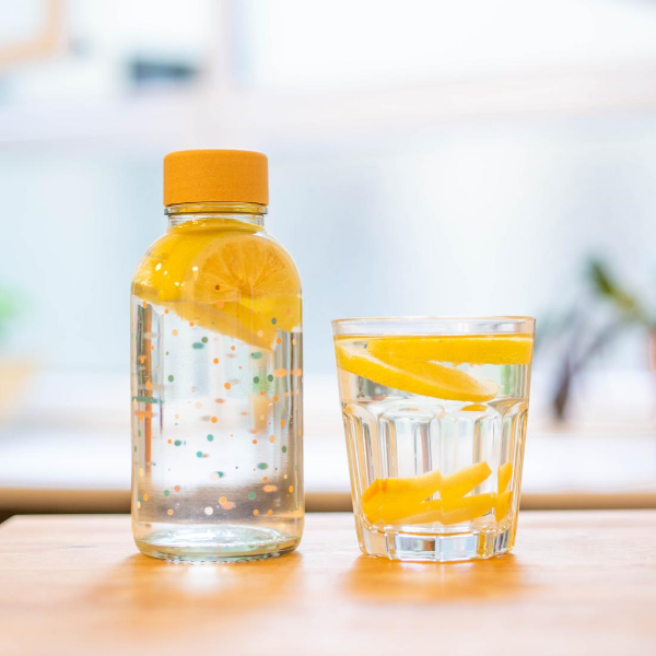 Glastrinkflasche mit bunten Punkten klein mit Zitronenwasser